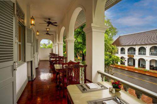 a porch of a house with a table and chairs at Villa Santi Hotel in Luang Prabang