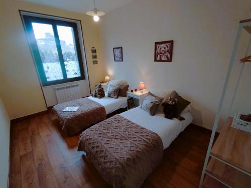 une chambre avec deux lits avec des ours en peluche assis sur eux dans l'établissement Le Pavin confort - Résidence de Michèle Murol, à Murol