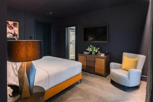 a bedroom with a bed and a desk and a chair at The Goethe Hotel - Small Luxury Hotels of the World in Rome