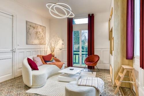 un salon avec un canapé et une chaise dans l'établissement Rose écrin de charme avec parking terrasse privée et jardin partagé, à Grand-Couronne
