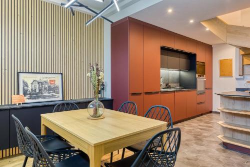 une salle à manger avec une table et des chaises en bois dans l'établissement Rose écrin de charme avec parking terrasse privée et jardin partagé, à Grand-Couronne