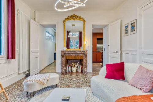 un salon avec un canapé et une cheminée dans l'établissement Rose écrin de charme avec parking terrasse privée et jardin partagé, à Grand-Couronne