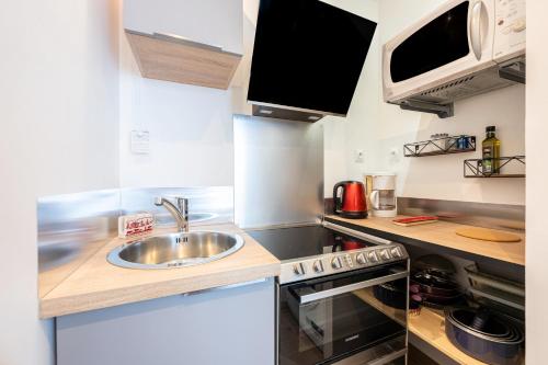 une petite cuisine avec un évier et un micro-ondes dans l'établissement Pierra Menta - Vue montagne station à pied, à Peisey-Nancroix