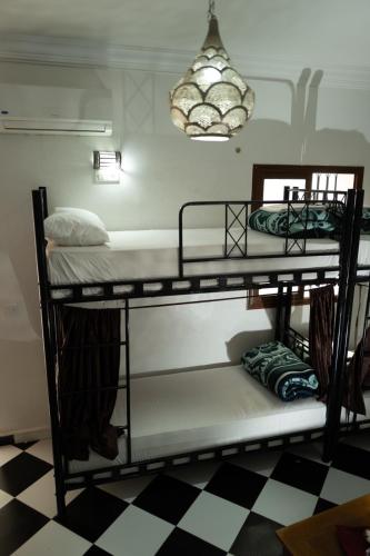 two bunk beds in a room with a checkered floor at Hostel Amour d'auberge in Marrakech
