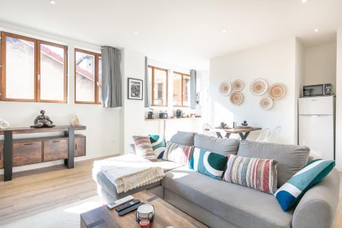 a living room with a couch and a table at Le Repos du Mélomane - A 1h de Lyon climatisé in La Côte-Saint-André