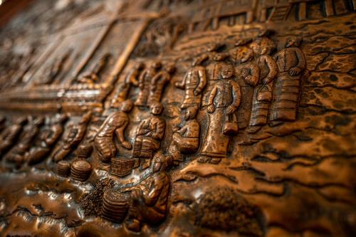 a close up of a wooden object with drawings on it at Villa Santi Hotel in Luang Prabang