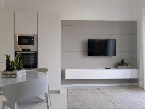 a white kitchen with a tv on a wall at Apartament and suite cavour 106 in Palermo