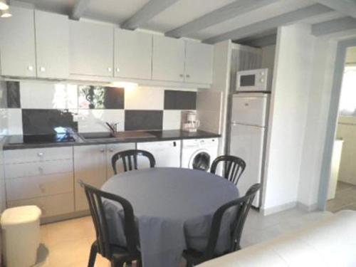 une cuisine avec une table et des chaises dans une cuisine dans l'établissement Maison 2 pièces mezzanine - Gruissan Ayguades AY090-025, à Vires