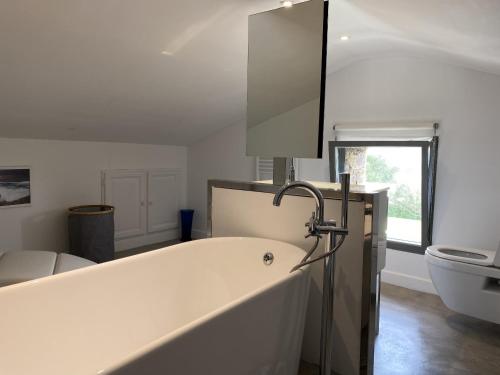 une salle de bain blanche avec une baignoire et un lavabo dans l'établissement Villa d exception vue mer panoramique piscine, à Saint-Florent