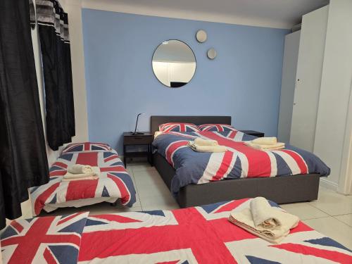 a bedroom with two beds with red white and blue at Studio apt with HUGE balcony near Oxford st - Marble arch - HydePark in London
