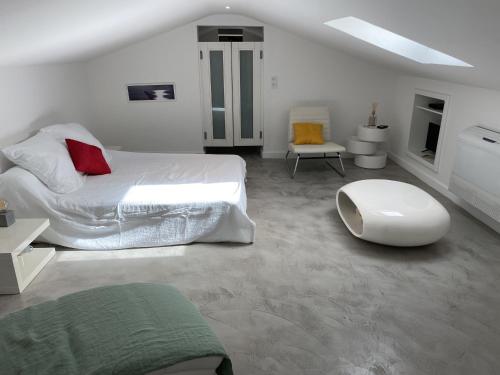 une chambre blanche avec un lit et une chaise dans l'établissement Villa d exception vue mer panoramique piscine, à Saint-Florent