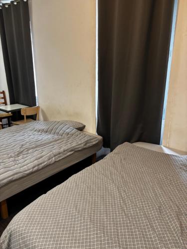 - 2 lits dans une petite chambre avec des rideaux dans l'établissement Studio 301 vieux port opéra, à Marseille
