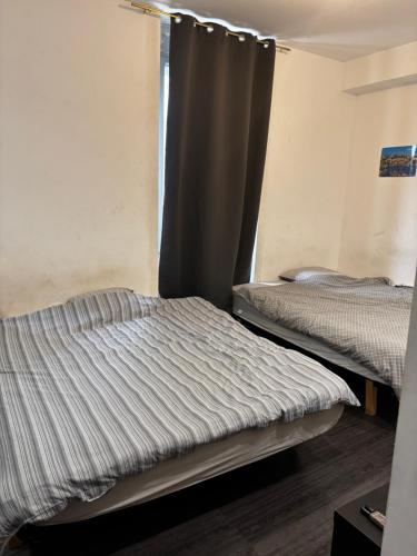 deux lits dans une chambre avec une fenêtre dans l'établissement Studio 301 vieux port opéra, à Marseille