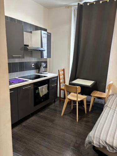 - une cuisine avec un évier, une table et des chaises dans l'établissement Studio 301 vieux port opéra, à Marseille