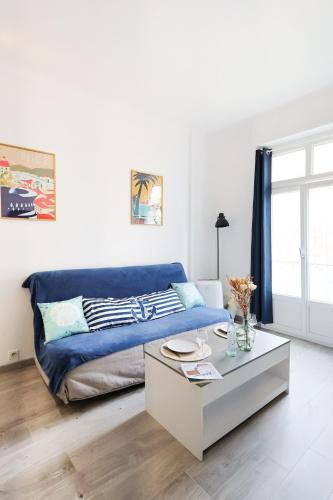 un salon avec un canapé bleu et une table basse dans l'établissement Appartement 2 pieces, à Nice