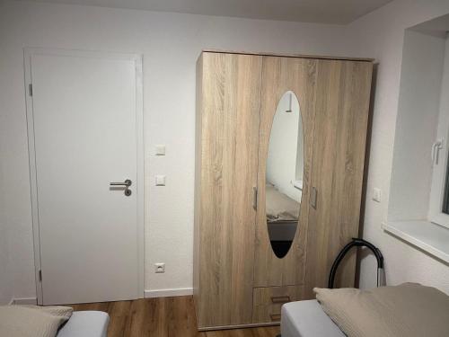 Cette chambre dispose d'une armoire en bois avec un miroir. dans l'établissement Sehr schöne und Modernisierte Wohnung mit moderne Wohnraumlüftung, à Pfedelbach