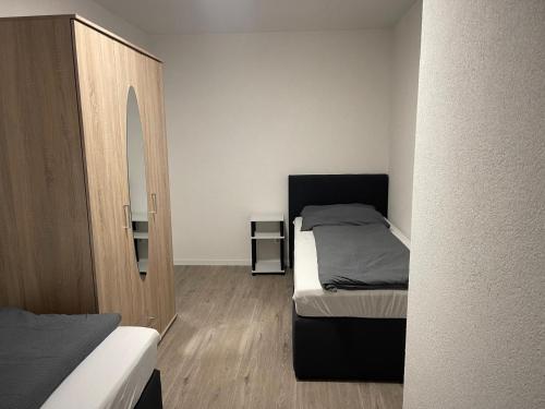 une petite chambre avec un lit et un miroir dans l'établissement Sehr schöne und Modernisierte Wohnung mit moderne Wohnraumlüftung, à Pfedelbach