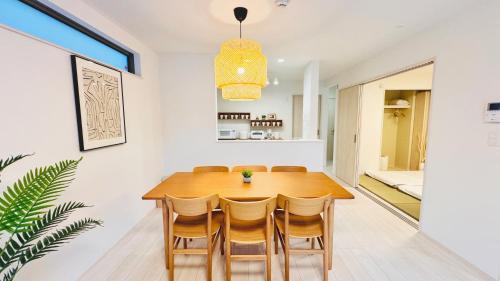 a dining room with a wooden table and chairs at Ireach Nago Okinawa in Nago