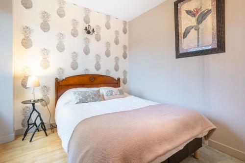 a bedroom with a bed and a picture on the wall at Les logis de Kergoulou in Concarneau