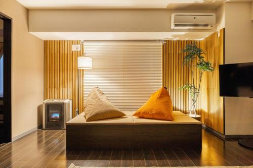 a couch with two pillows on it in a room at Cozy Stay Sapporo Hongodori 605 in Sapporo
