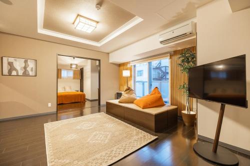 a living room with a couch and a flat screen tv at Cozy Stay Sapporo Hongodori 605 in Sapporo