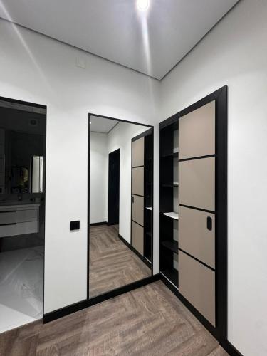 Habitación con 2 puertas y espejo. en Apartment on Mukanova street, en Karagandá
