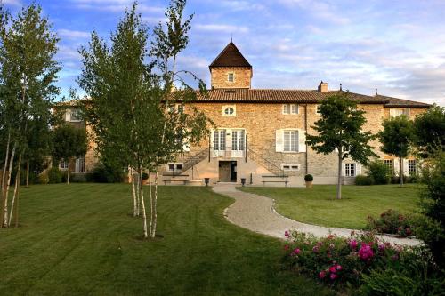 a large brick building with a tower on top of it at Hôtel-Restaurant le Château de Besseuil, Mâcon Nord - Teritoria in Clessé