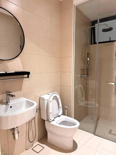 a bathroom with a toilet and a sink and a shower at The Apple Melaka in Melaka