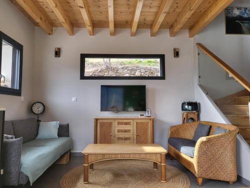 un salon avec un canapé et une télévision dans l'établissement Chalet de montagne, Piscine avec vue et bain nordique, à Châteauroux-les-Alpes