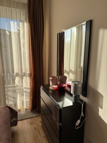 a bedroom with a dresser with a mirror and a window at Borovets Gardens MVS Apart D42 in Borovets