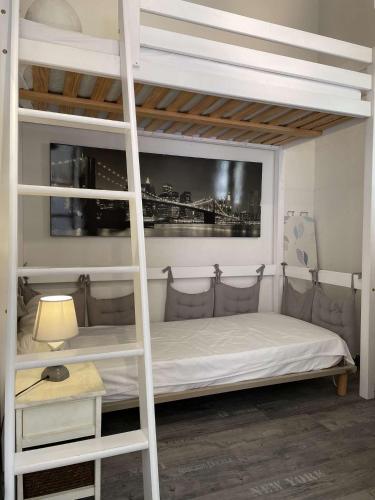 une chambre avec un lit superposé avec une échelle dans l'établissement NP160-445 Pavillon 2 pièces mezzanine Narbonne Plage, à Narbonne-Plage