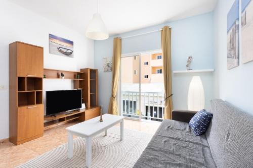 un soggiorno con un divano e una TV di Apartamento La Arena Rosa a Candelaria