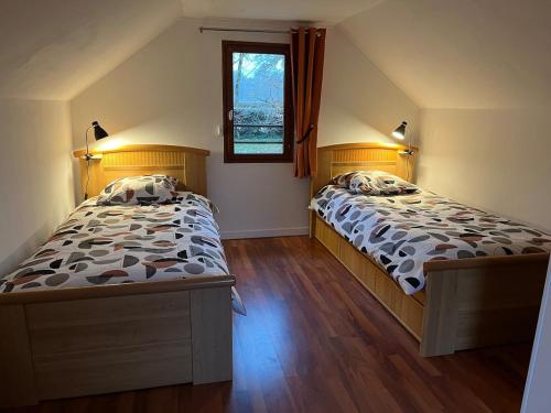 ein Schlafzimmer mit zwei Betten und einem Fenster in der Unterkunft Maison au calme au pied du parc Saint Pierre, proche cathédrale, hortillonnages et gare in Amiens