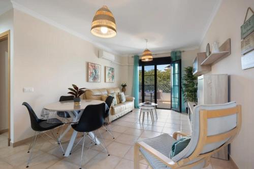 a living room with a table and chairs at Golden Sands Apartment - Chiclana de la frontera in Novo Sancti Petri