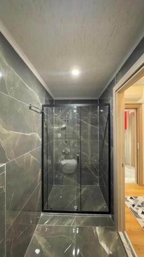 a bathroom with a glass shower with a sink at Lions Boutique Hotel in Altınova