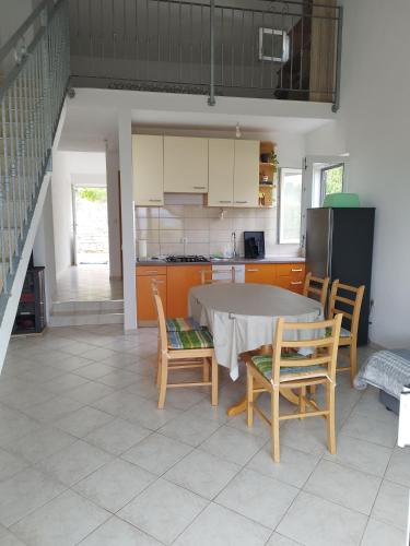 a kitchen with a table and chairs in a room at Apartmani Edi in Gdinj