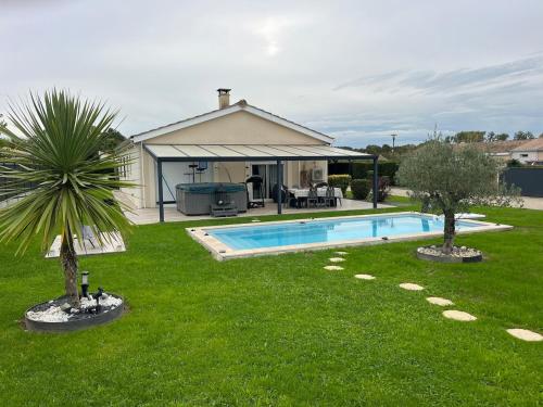 une arrière-cour avec une piscine et deux arbres dans l'établissement Villa tout confort sur Teuillac, à Teuillac