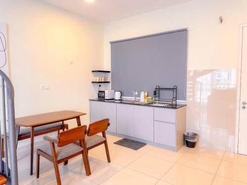 a kitchen with a table and a table and chairs at The Apple Melaka in Melaka