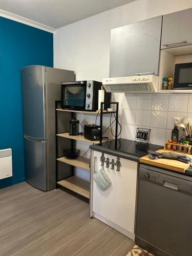 a kitchen with a refrigerator and a stove top oven at Niort Home in Niort