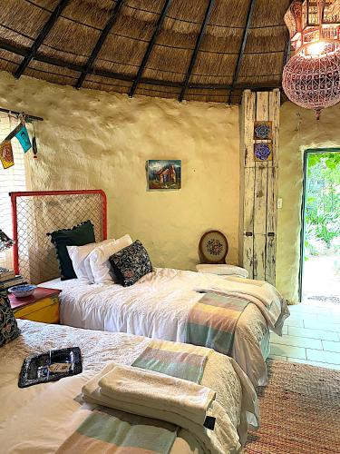 a bedroom with two beds and a chandelier at ilyn pottery cottage in Pretoria