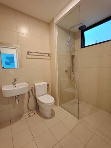 a bathroom with a toilet and a glass shower at The Apple Melaka in Melaka