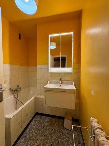 une salle de bain avec un lavabo, une baignoire et un miroir dans l'établissement Appartement avec terrasse vue sur piste à Praloup, à Uvernet