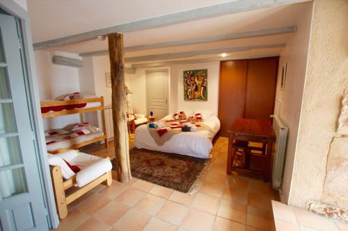 une chambre avec deux lits et un lit superposé dans l'établissement Les maisons d'en haut & Piscine à débordement chauffée, à Saint-Rémy