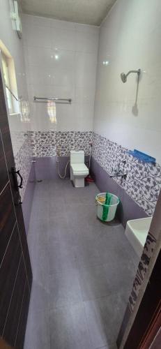 a bathroom with a toilet and a sink and a tub at Karpagam Residency in Ooty
