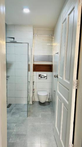 un bagno con wc e porta a vetri di Rome Home a Dodoma