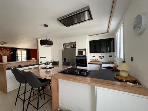 - une cuisine avec un comptoir et une cuisinière four supérieur dans l'établissement Maison clim-jardin - proche mer - 6 couchages - ideal planchistes, à Sigean