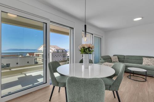 a dining room with a table and chairs and a couch at Apartment Antonela - Makarska Exklusiv in Tučepi