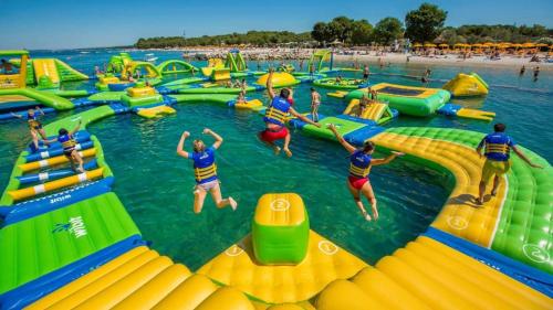 a group of people jumping in the water at a water park at Chez Juline charmante maison de plain pied à la campagne et au calme in Bourg-Fidèle