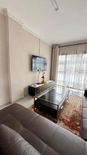 a living room with a couch and a glass table at cozy home in traquil area in Empangeni