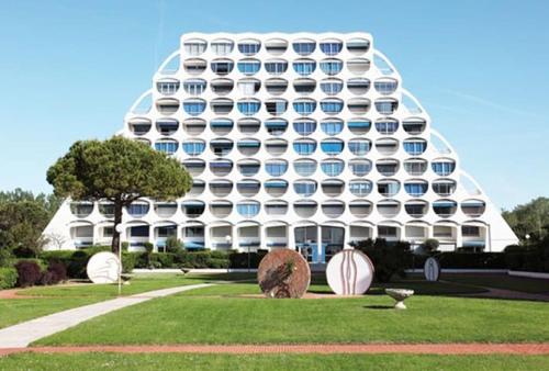 un grand bâtiment blanc avec beaucoup de fenêtres dans l'établissement Port & Plage - Studio avec Parking, à La Grande Motte